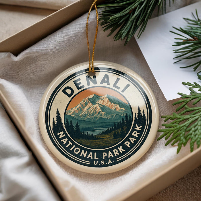A decorative ornament with a mountain landscape and pine trees, featuring the text "DENALI NATIONAL PARK PARK U.S.A."