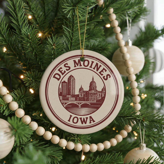 A Christmas tree decorated with ornaments, including a circular ornament with the text "DES MOINES IOWA" and a cityscape design.