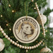 A circular ornament on a Christmas tree featuring a dog's head and the text "DOGO ARGENTINO".