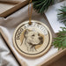 A circular ornament with a dog's head and the text "DOGO ARGENTINO" printed on it, hanging from a string.