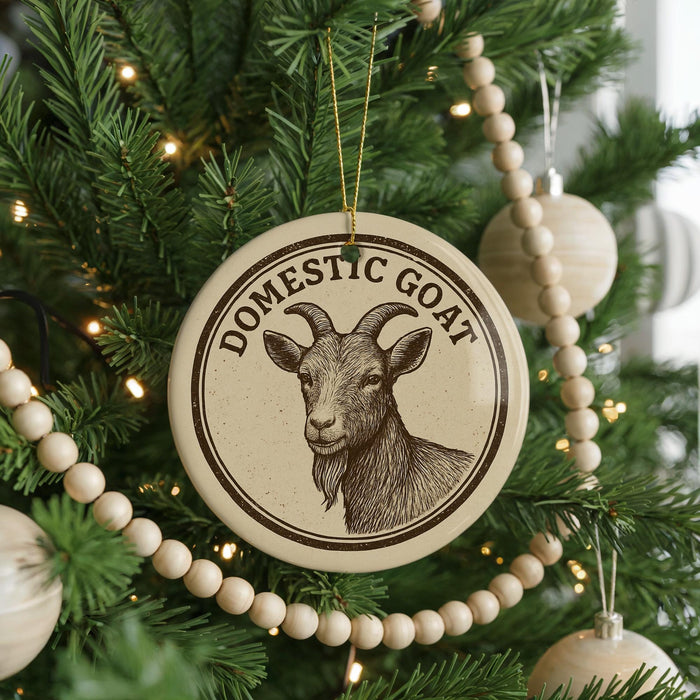 A Christmas tree decorated with ornaments, including a circular ornament with a goat image and the text "Domestic Goat" on it.