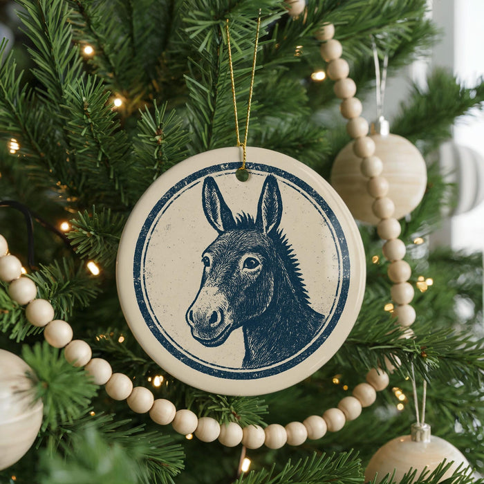 A Christmas tree decorated with ornaments, including a circular ornament featuring a donkey's head.