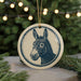 A circular ornament featuring a donkey's head is displayed in front of a blurred background of Christmas lights.