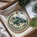 A round ornament with a blue and white design featuring a fish, hanging from a string.