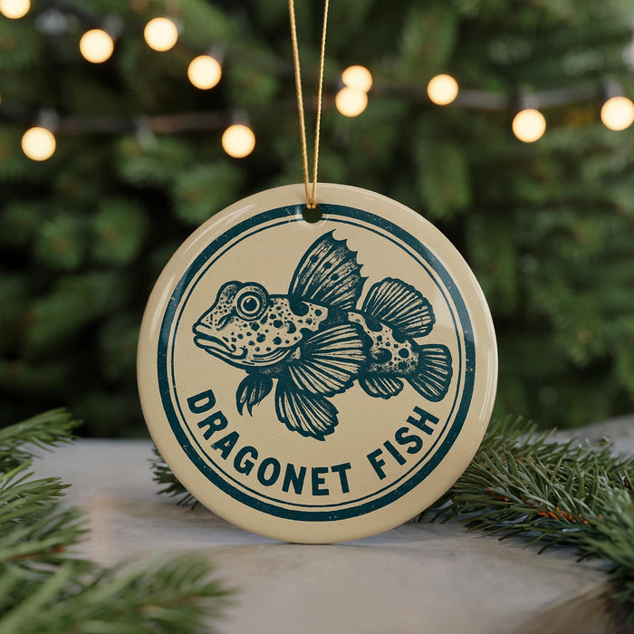 A round ornament with a blue and white design featuring a fish, hanging from a string.