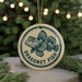 A round ornament with a blue and white design featuring a fish, hanging from a string.