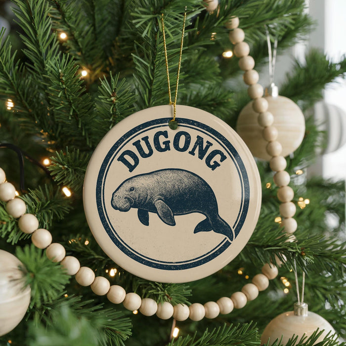 A Christmas tree decorated with ornaments, including a circular ornament with a manatee and the word "Dugong" written on it.