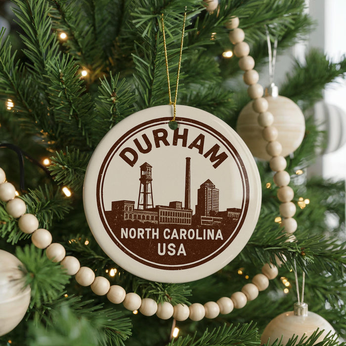 A Christmas tree decorated with ornaments, including a circular ornament with the text "DURHAM NORTH CAROLINA USA" and a water tower silhouette.