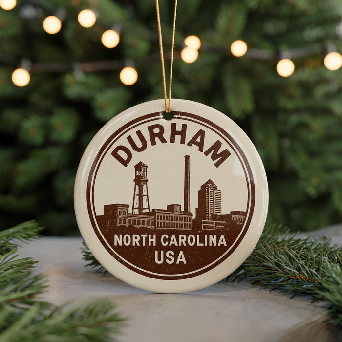 A circular ornament with the text "DURHAM NORTH CAROLINA USA" printed on it, featuring a silhouette of a city skyline.
