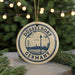 A circular ornament with the text "DÜSSELDORF GERMANY" and an illustration of a city skyline, hanging from a string.