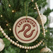 A Christmas tree decorated with ornaments, including a circular ornament with the text "Earthworm" and a wooden bead decoration.