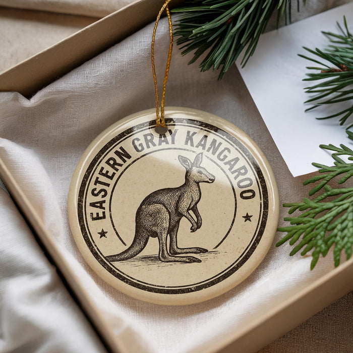 A circular ornament featuring a kangaroo, with the text "EASTERN GRAY KANGAROO" printed on it, is displayed in a box with pine branches.