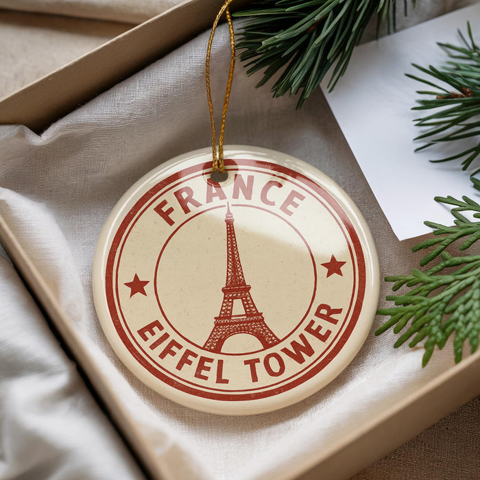 A round ornament with the Eiffel Tower printed on it, hanging from a string.