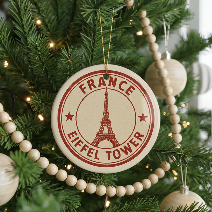 A Christmas tree decorated with ornaments, including a circular ornament with the Eiffel Tower and the text "FRANCE EIFFLÉT TOWER" on it.