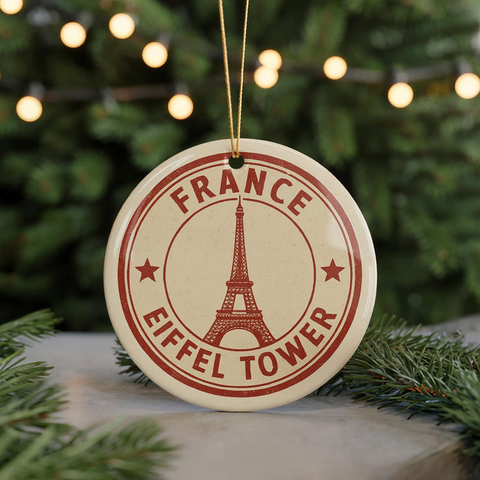 A circular ornament with the Eiffel Tower and the text "FRANCE" printed on it, hanging from a string.