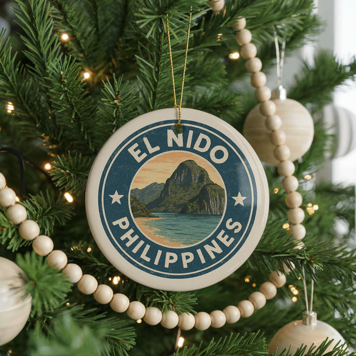 A Christmas tree decorated with ornaments, including a circular ornament with the text "EL NIDO PHILIPPINES" and a scenic image of a mountain and ocean.