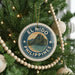 A Christmas tree decorated with ornaments, including a circular ornament with the text "EL NIDO PHILIPPINES" and a scenic image of a mountain and ocean.