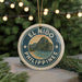 A round ornament with the text "EL NIDO PHILIPPINES" and a mountain landscape design, hanging from a string.