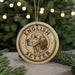 A circular ornament with the text "ENGLISH SETTER" and a depiction of a dog's head is displayed in front of a Christmas tree with twinkling lights.