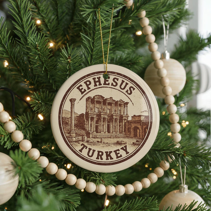 A circular ornament on a Christmas tree, featuring an illustration of the ancient city of Ephesus, Turkey.