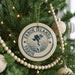 A Christmas tree decorated with ornaments, including a circular ornament with the text "Faroe Islands" and a map of the Faroe Islands.