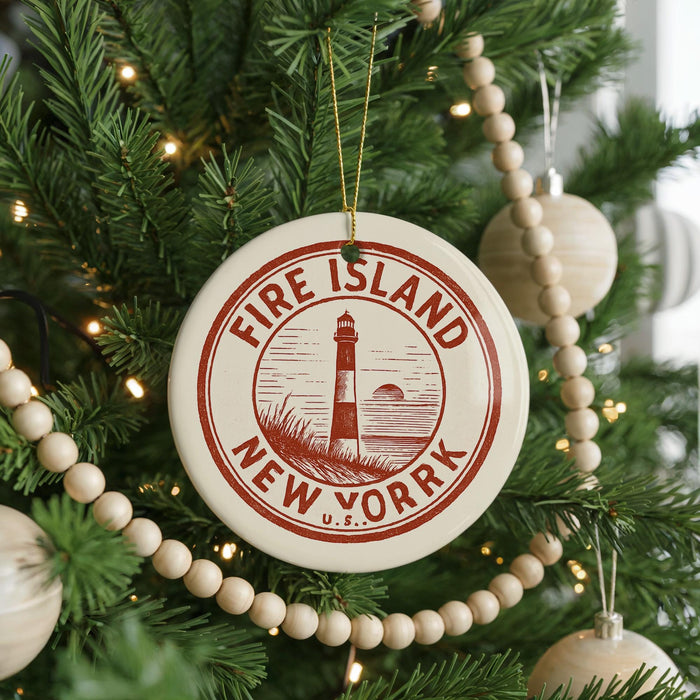 A Christmas tree decorated with ornaments, including a circular ornament with the text "FIRE ISLAND NEW YORK" and a lighthouse image.