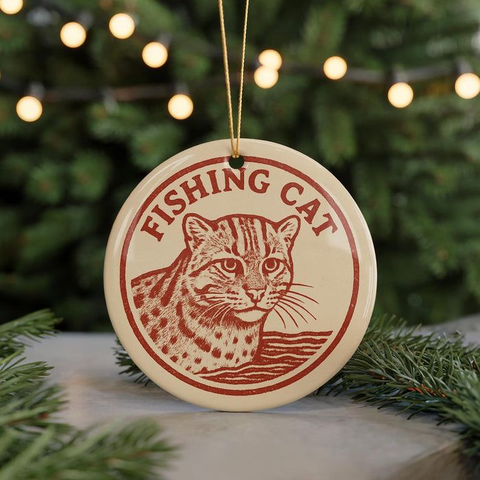 A round ornament with a cat image and the text "FISHING CAT" on it, hanging from a string.