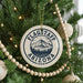 A Christmas tree decorated with ornaments, including a circular ornament with the text "Flagstaff Arizona USA" and a mountain illustration.