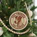 A round ornament on a Christmas tree featuring a fox terrier dog's head, with the text "FOX TERRIER" around the edge.