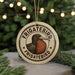 A circular ornament with the text "FRIGATEBIRD FRIGATEBIRD" and an illustration of a bird, hanging from a string.