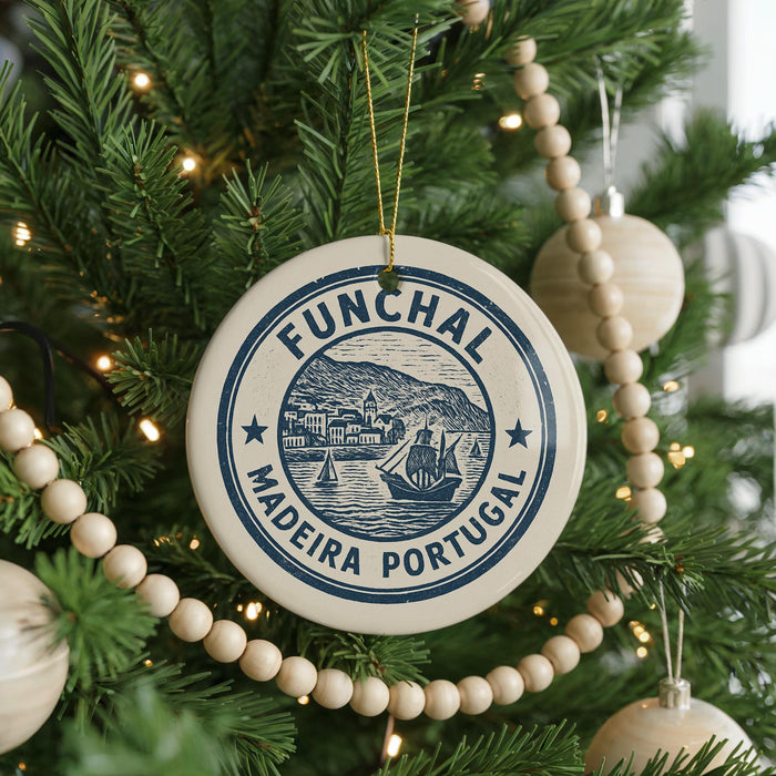 A Christmas tree decorated with ornaments, including a circular ornament with the text "FUNCHAL MADEIRA PORTUGAL" and a ship illustration.