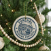 A Christmas tree decorated with ornaments, including a circular ornament with the text "FUNCHAL MADEIRA PORTUGAL" and a ship illustration.