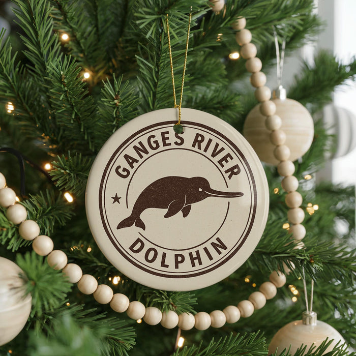 A Christmas tree decorated with ornaments, including a round ornament with a graphic of a dolphin and the text "Ganges River Dolphin".