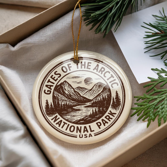 A circular ornament with the text "Gates of the Arctic National Park USA" printed on it, surrounded by pine branches and pine needles.