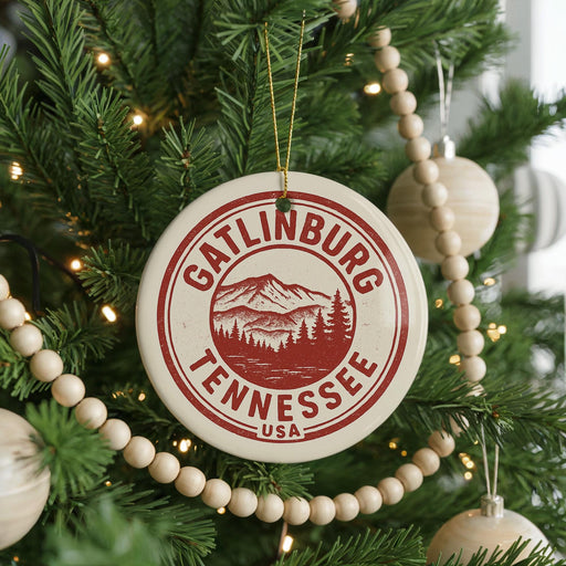 A Christmas tree decorated with ornaments, including a circular ornament with the text "GATLINBURG TENNESSEE USA" and a mountain landscape design.