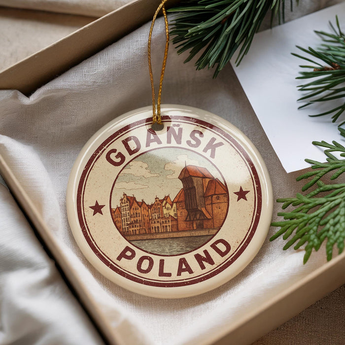 A circular ornament with the text "Gdansk Poland" and an illustration of a cityscape, hanging from a string.