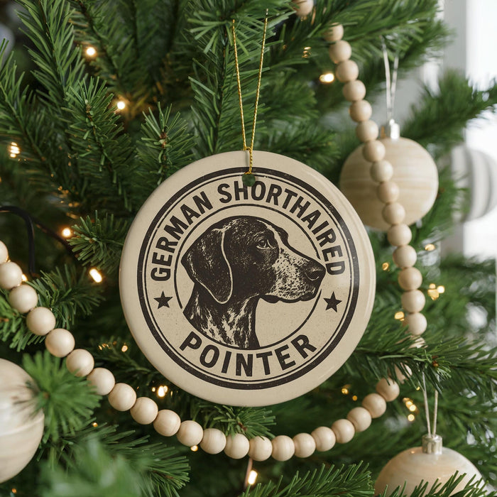 A Christmas tree decorated with ornaments, including a round ornament with a black and white image of a German Shorthaired Pointer dog and the text "German Shorthaired Pointer" around the edge.