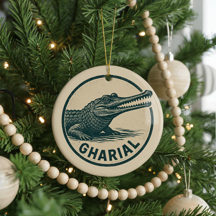 A Christmas tree decorated with ornaments, including a circular ornament with a crocodile image and the word "GHARIAL" written on it.