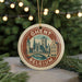 A circular ornament with a picture of a city skyline and the text "Ghent, Belgium" on it, hanging from a string.
