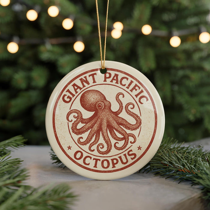 A round ornament with the text "GIANT PACIFIC OCTOPUS" and an illustration of an octopus is displayed on a table, surrounded by pine branches and lights.