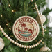 A round ornament on a Christmas tree with the text "GILF AIR INDONESIA" and a palm tree design.