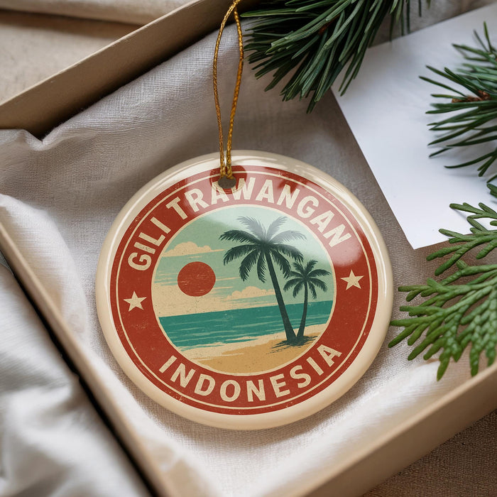 A round ornament with a tropical beach scene and palm trees, featuring the text "Gili Trawangan Indonesia" on it, is displayed in a box with pine branches.