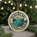 A circular ornament with the text "GLACIER BAY NATIONAL PPARK" and a mountain landscape design, hanging from a string.