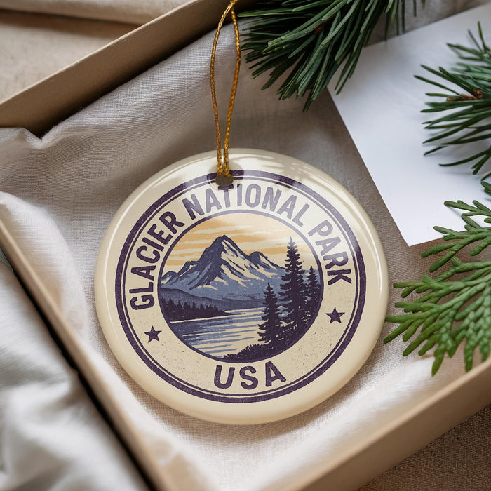 A circular ornament with the text "GLACIER NATIONAL PARK USA" and a mountain landscape design, hanging from a string.