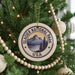 A Christmas tree decorated with ornaments, including a circular ornament with the text "GLACIER NATIONAL PARK USA" and a mountain landscape.