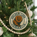 A round ornament on a Christmas tree featuring a golden lion and the text "GOLDEN LION TAMARIN".