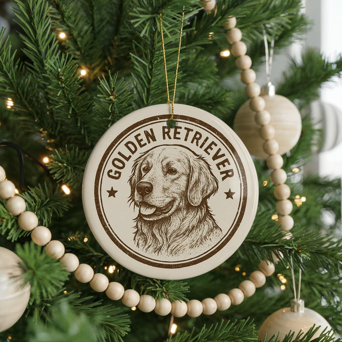 A round ornament with a golden retriever dog's face is hanging on a Christmas tree, surrounded by other ornaments and lights.
