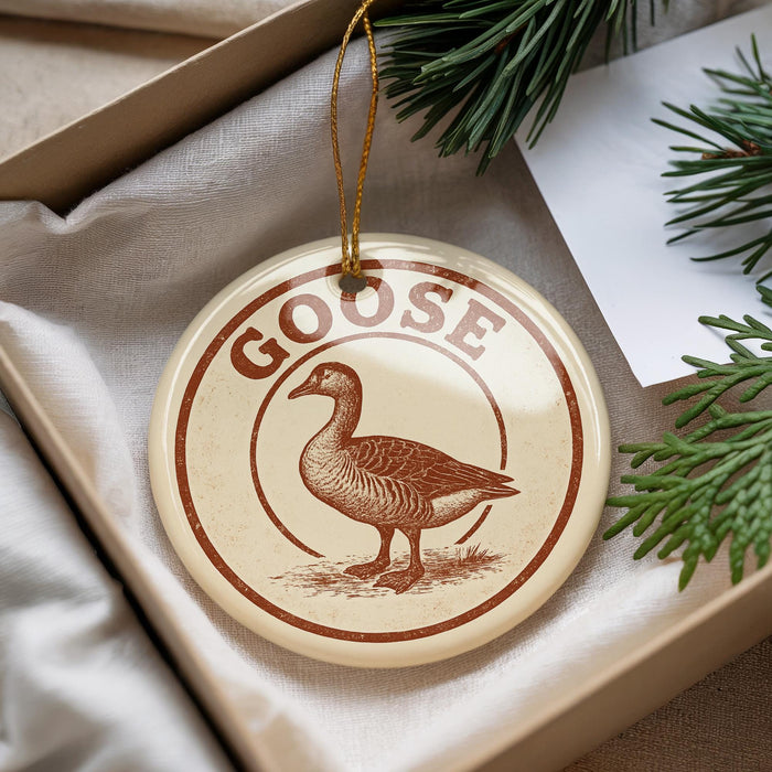 A circular ornament with the word "GOOSE" printed on it, featuring a depiction of a goose.