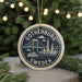 A circular ornament with the text "GOThenburg, Sweden" and an illustration of the Gothenburg Bridge, surrounded by greenery and twinkling lights.