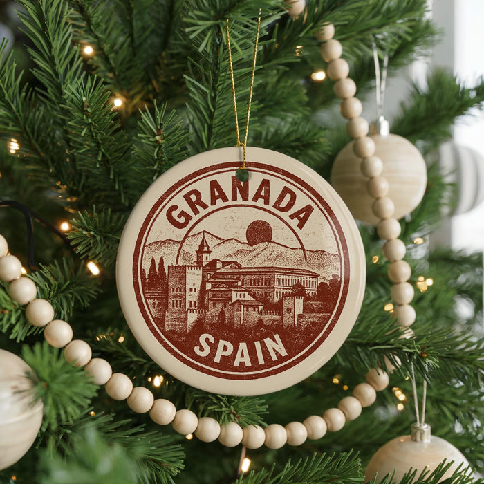 A circular ornament on a Christmas tree, featuring the text "GRANADA SPAIN" and an illustration of a cityscape.